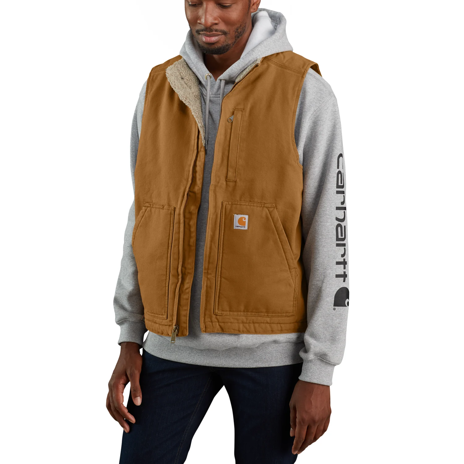 Mand i brun Carhartt 104277 duck-vest over en grå hættetrøje