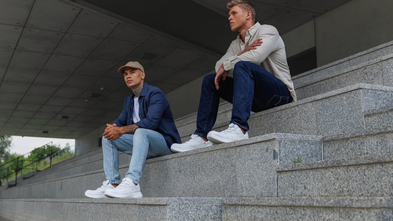 To mænd sidder på en betontrappe i hvide Airtox FW44 sikkerhedssko